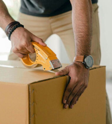 A man taping up a moving box