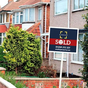 A house with an O'Malley Estate Agent sign in the garden which says 